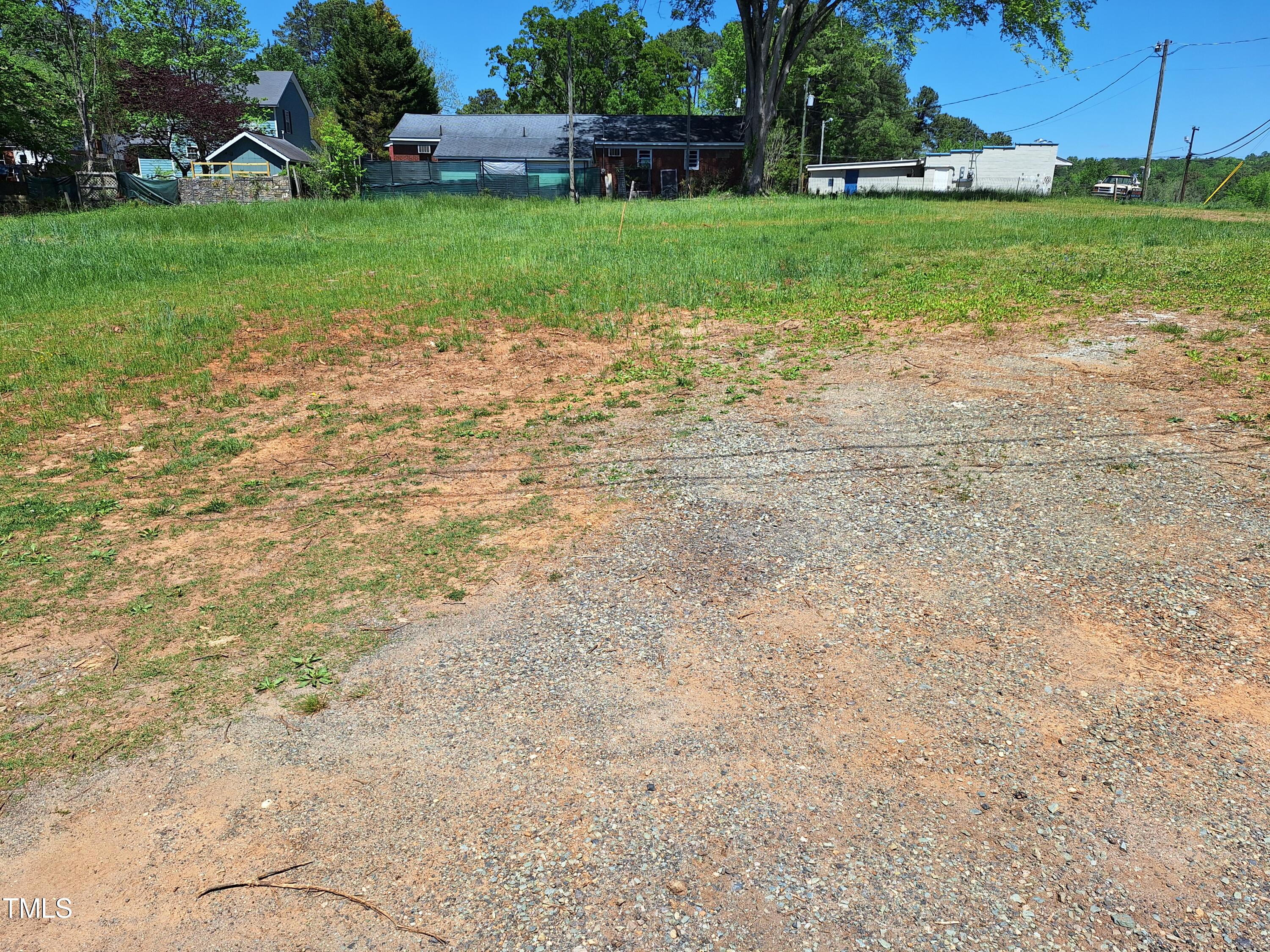 a view of a yard with plants and trees