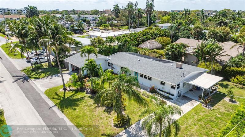 an aerial view of a house with a garden and lake view