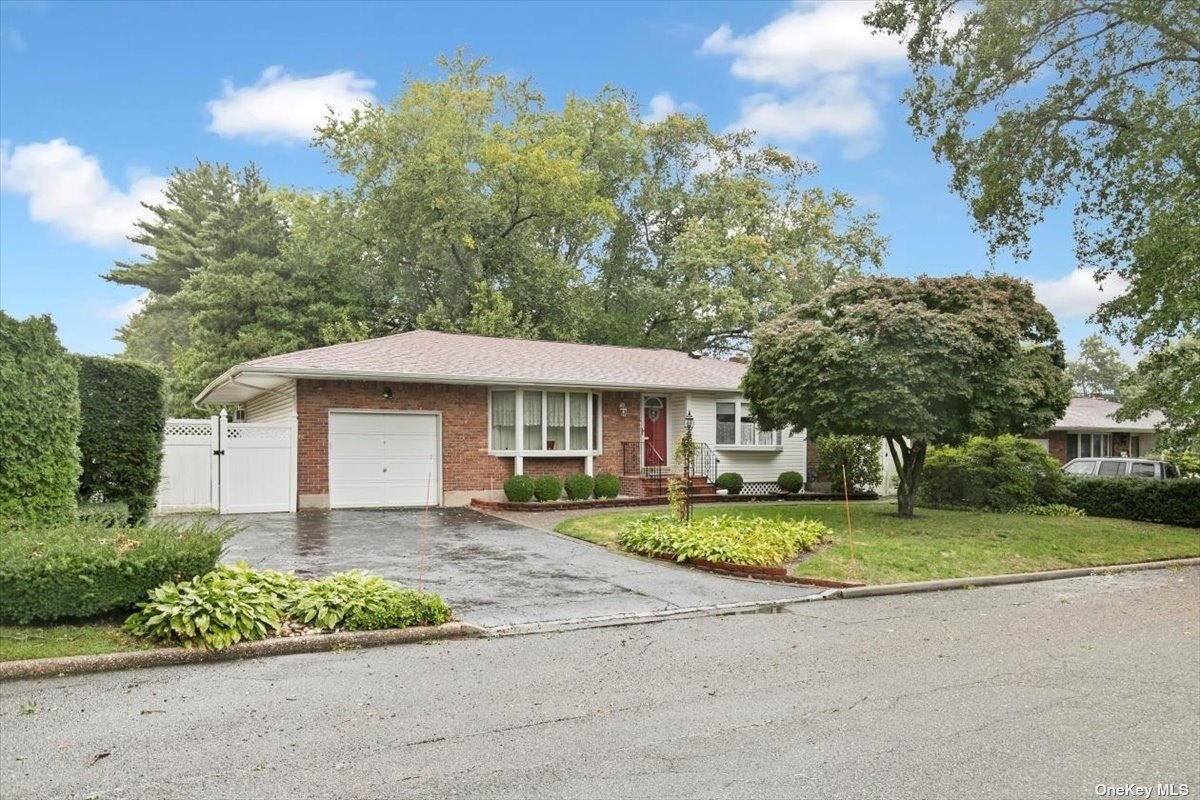 a front view of a house with a yard and trees