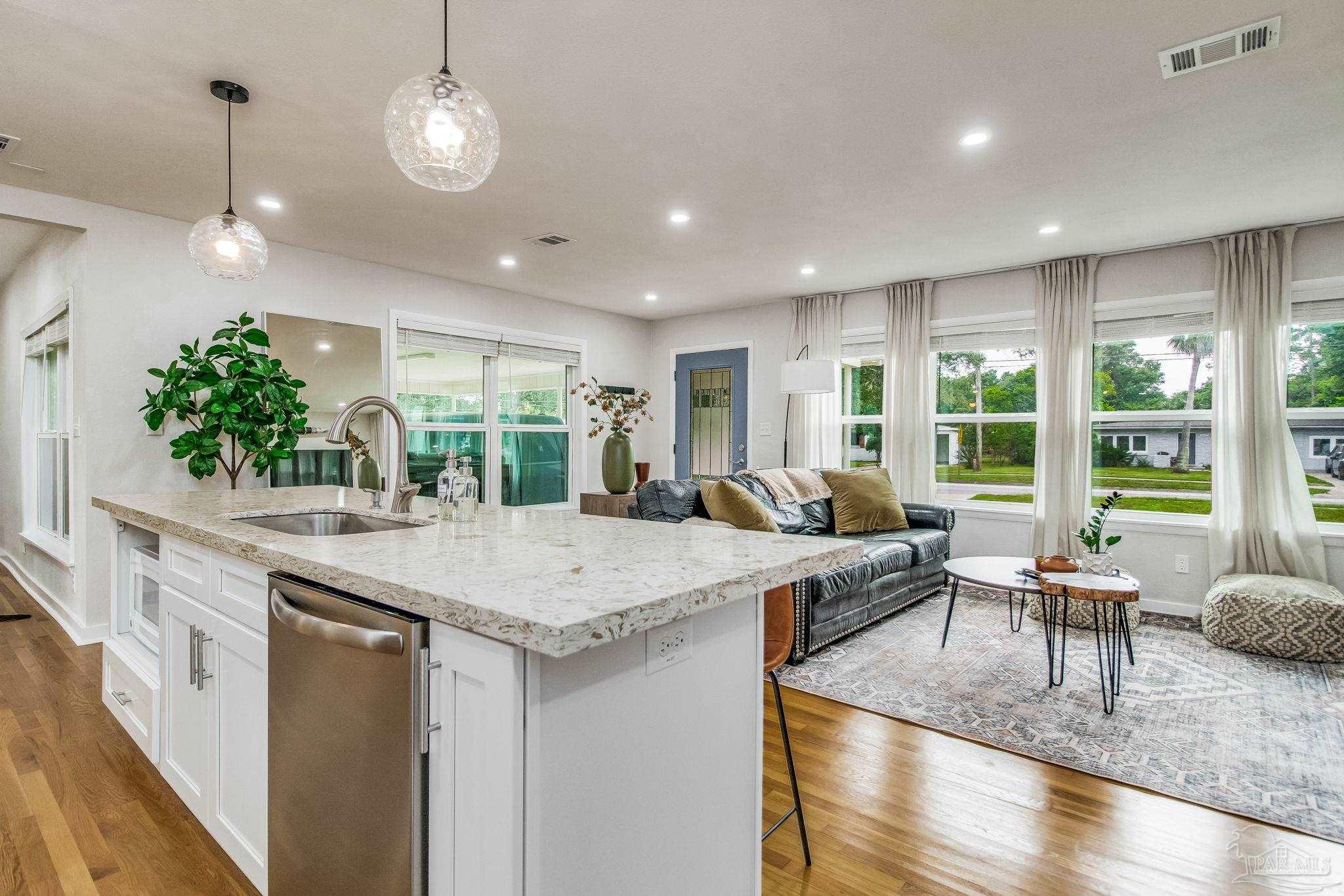 a view of living room kitchen with stainless steel appliances granite countertop living room and kitchen island