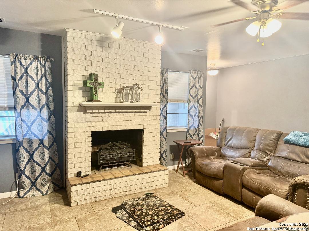 a living room with furniture a fireplace and a chandelier