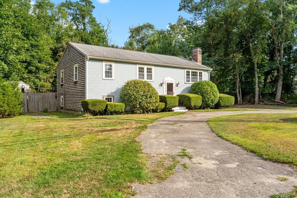 a view of a house with backyard and tree