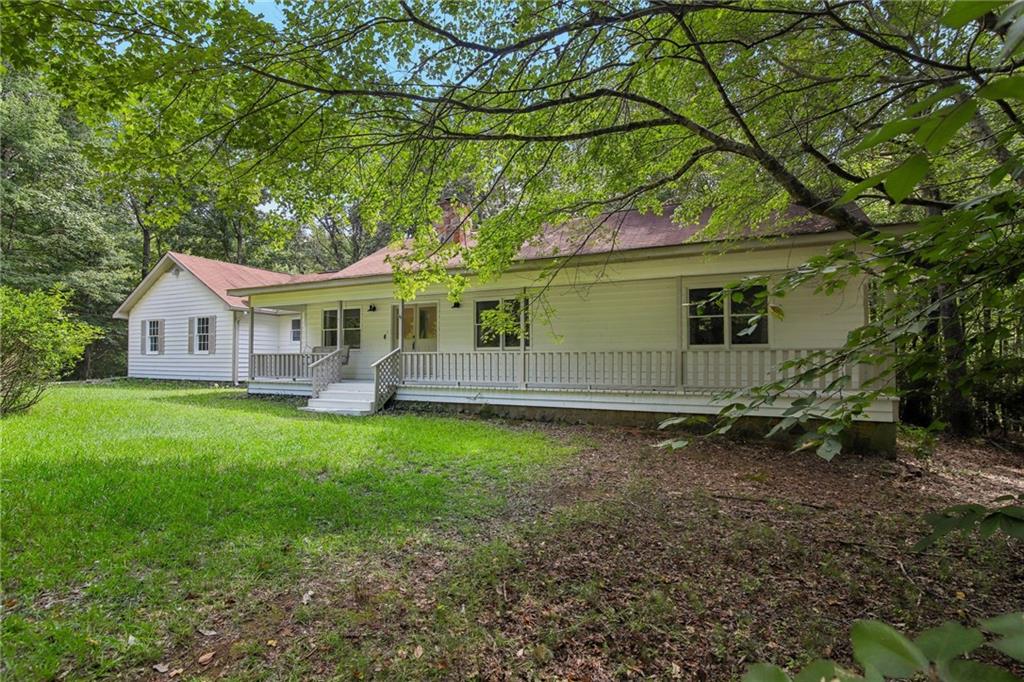 a backyard of a house with wooden fence and large trees