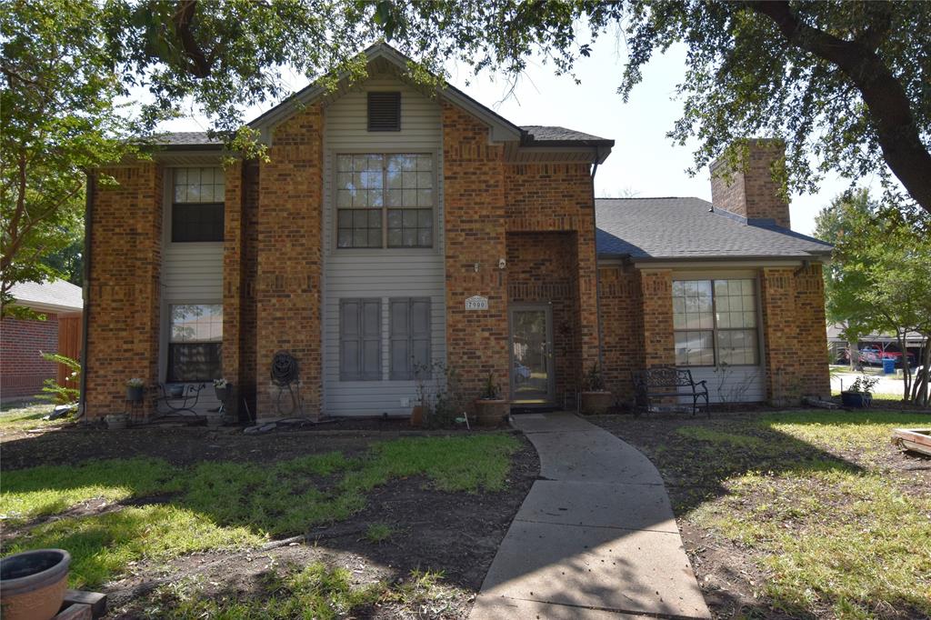 a front view of a house with a garden and yard