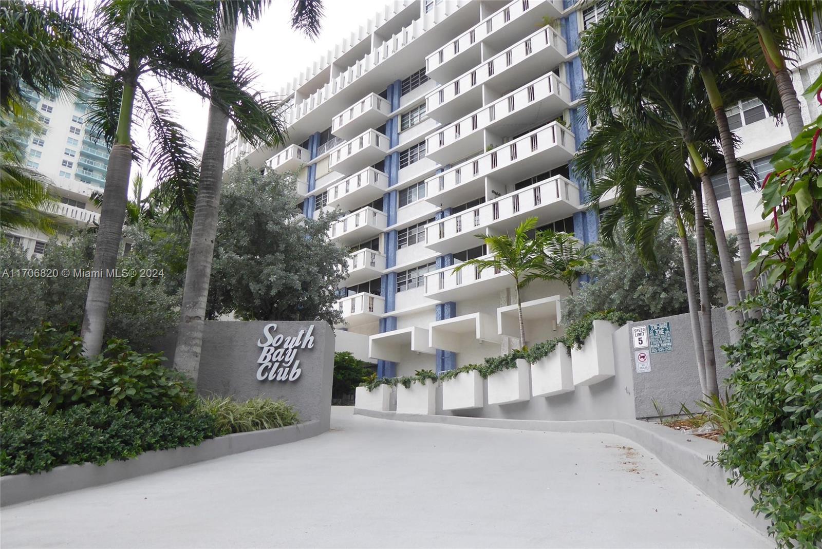 a view of a street with a building and large trees