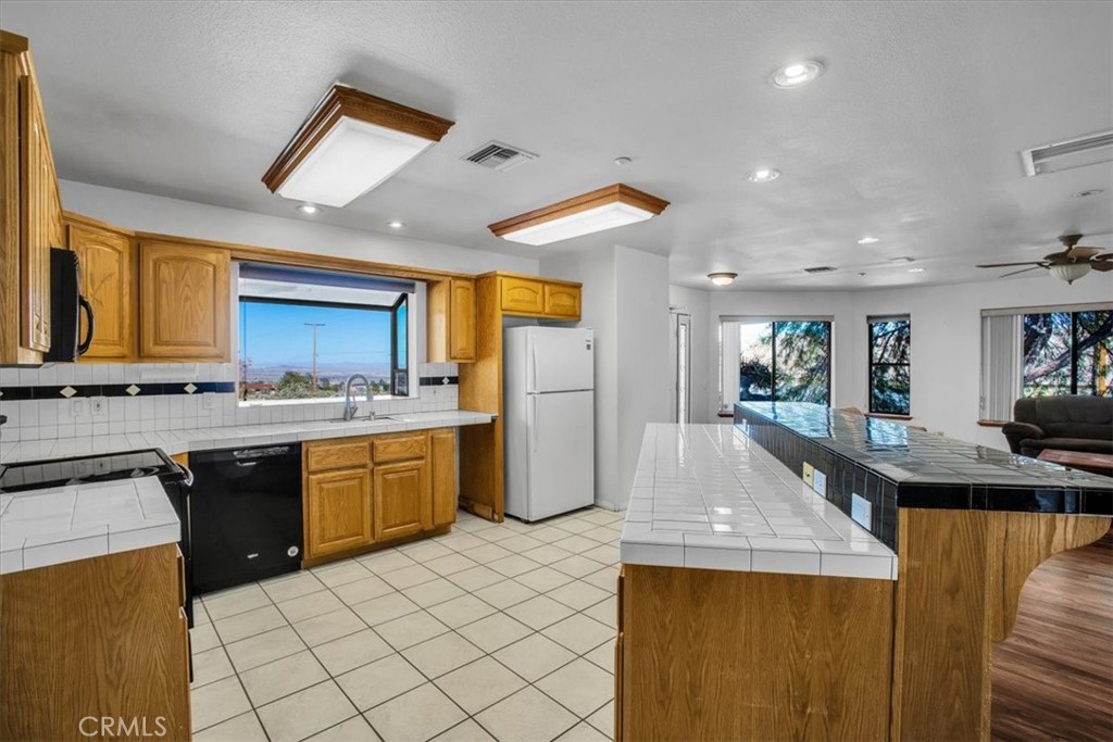 a kitchen with stainless steel appliances granite countertop a sink and a refrigerator