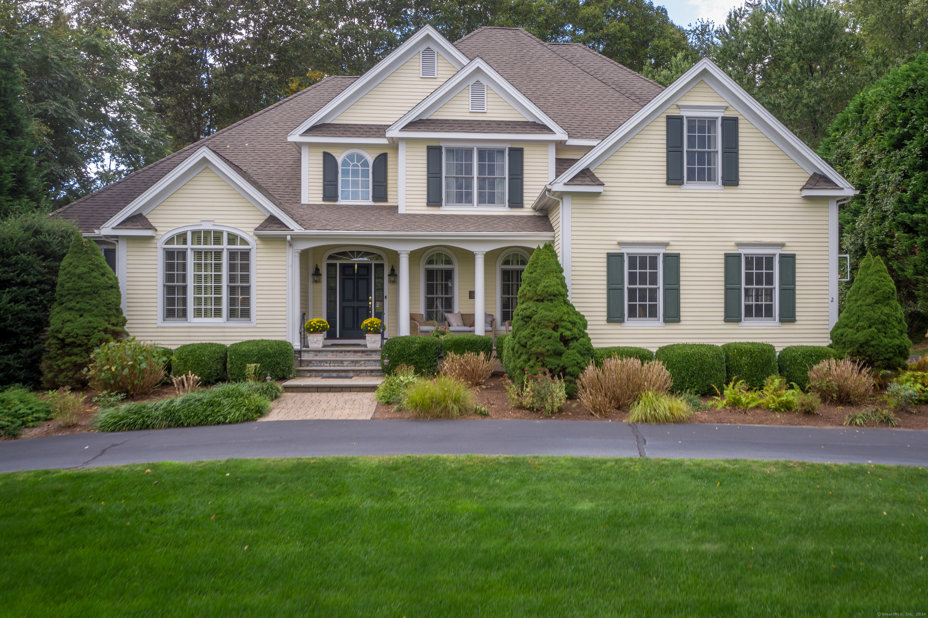 a front view of a house with a yard and potted plants