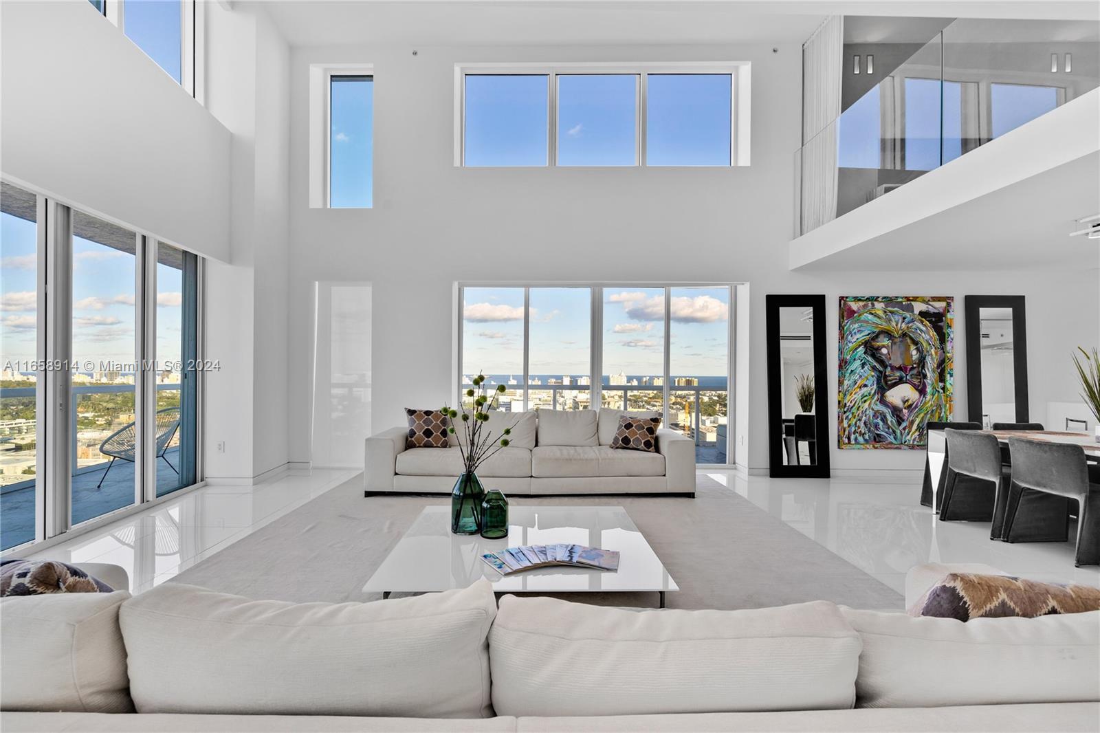 a living room with furniture and floor to ceiling windows