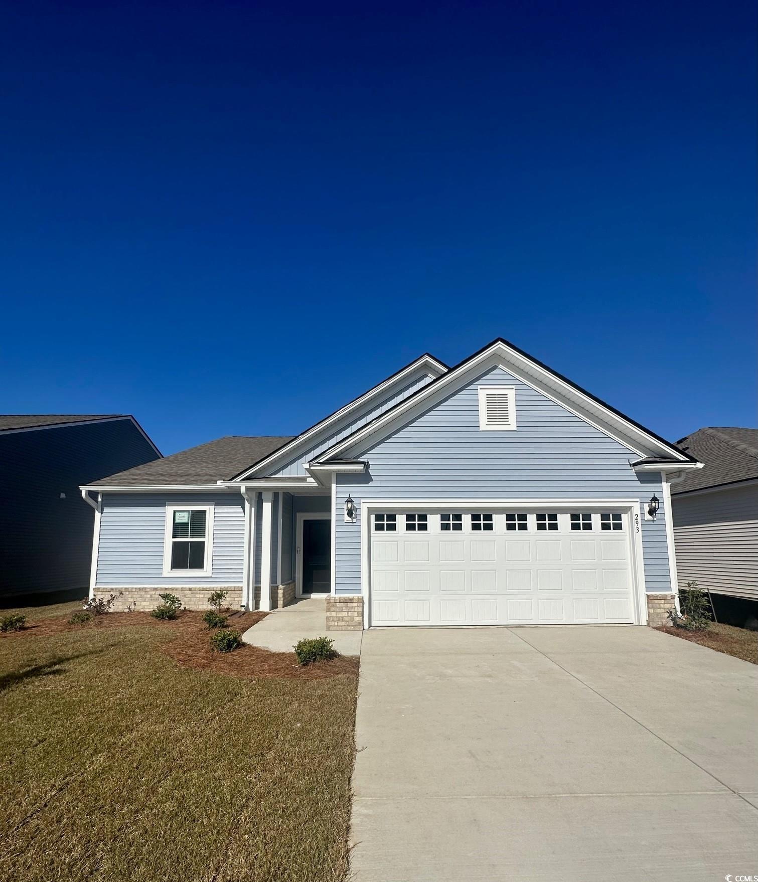 Single story home featuring a garage and a front y