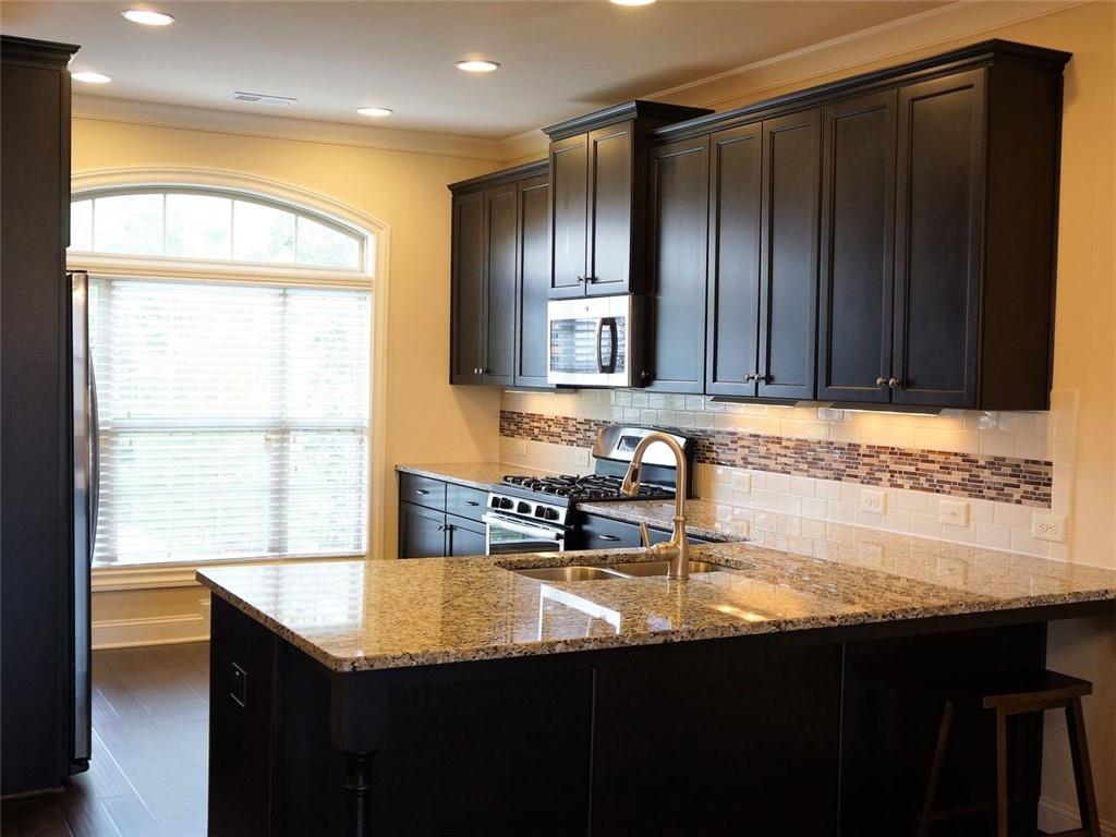 a kitchen with granite countertop a sink cabinets and wooden floor