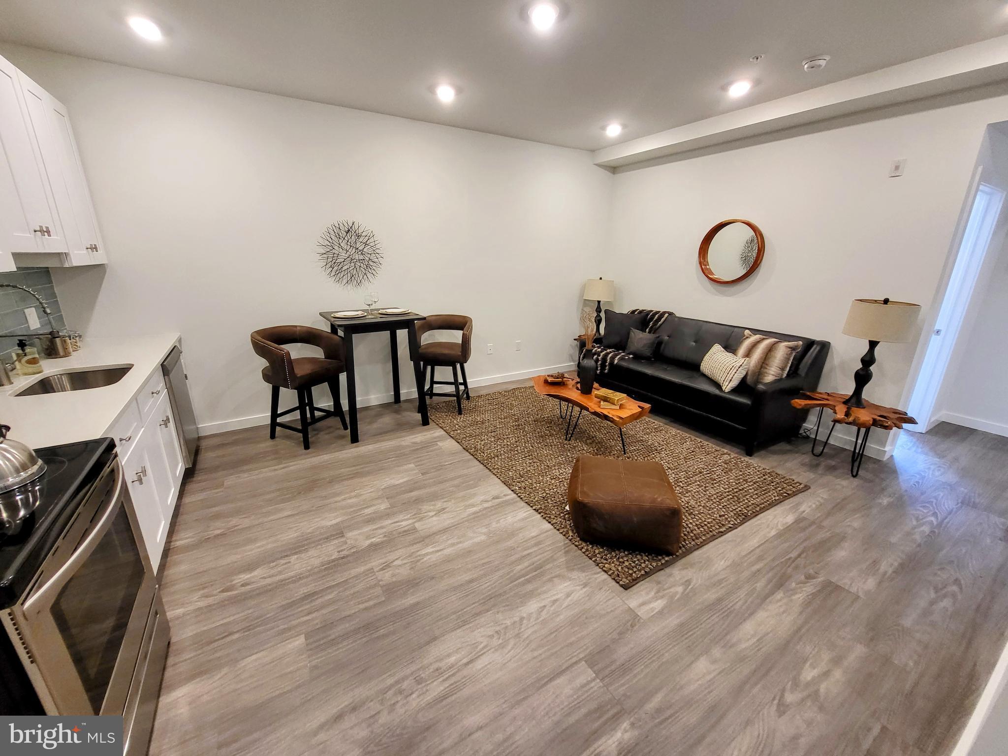 a living room with furniture and a wooden floor