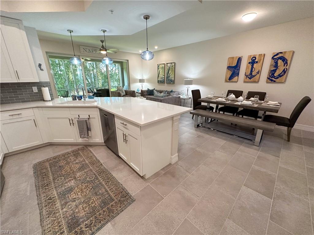 a large white kitchen with a stove a sink dishwasher and a fireplace with wooden floor