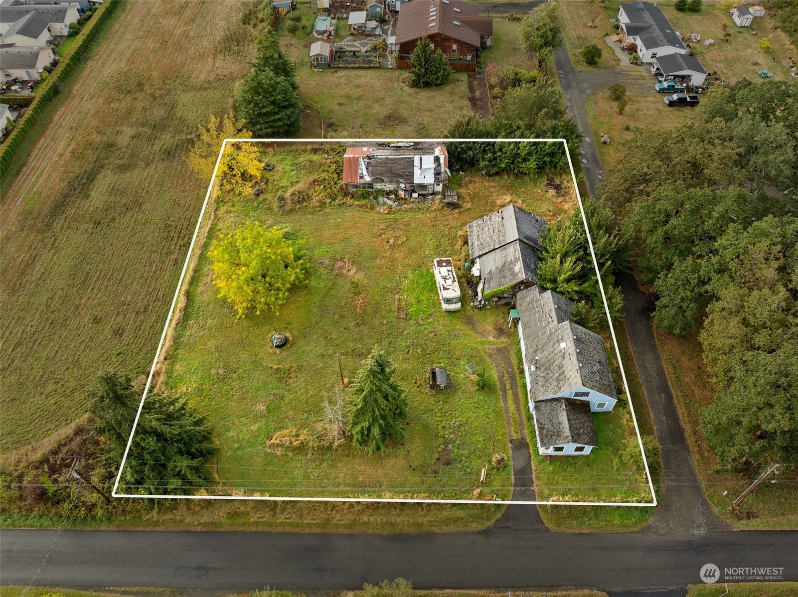 an aerial view of a residential houses with yard