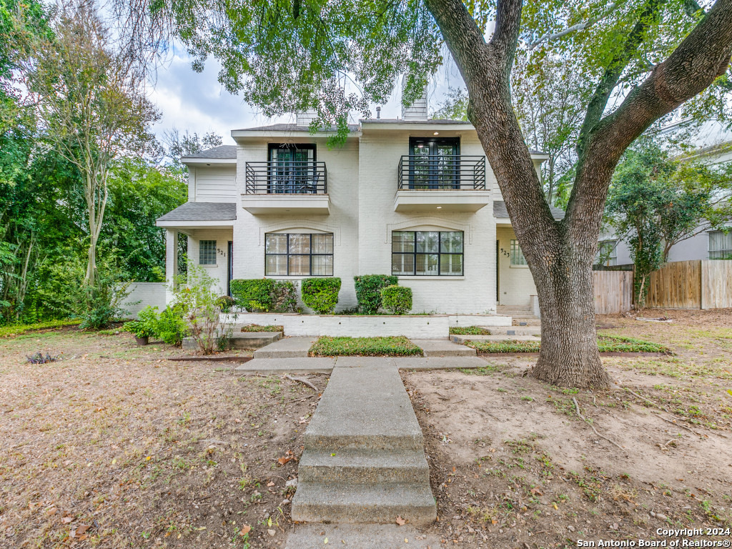 a front view of a house with a yard and trees