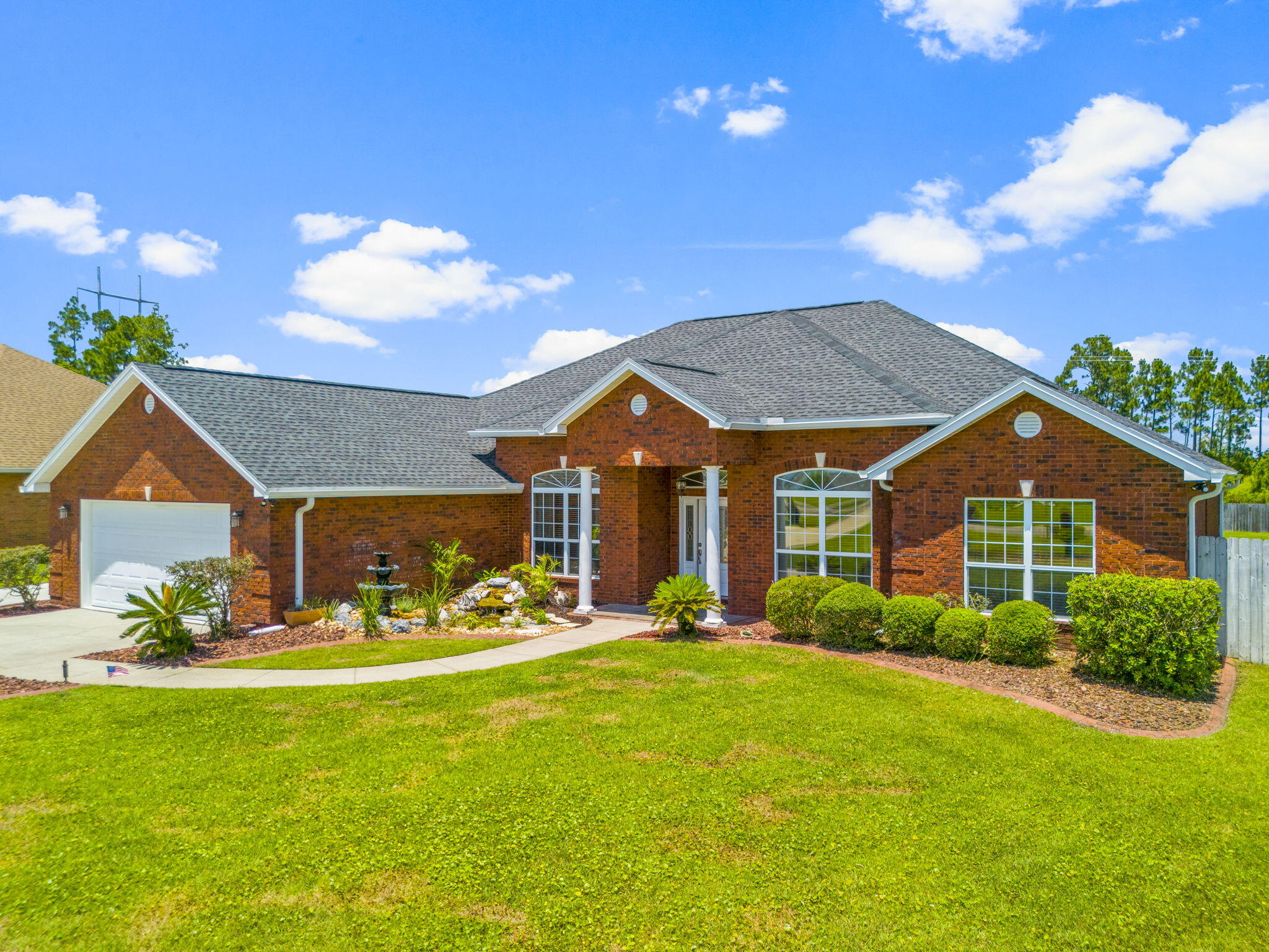 a view of a house with a big yard and potted plants