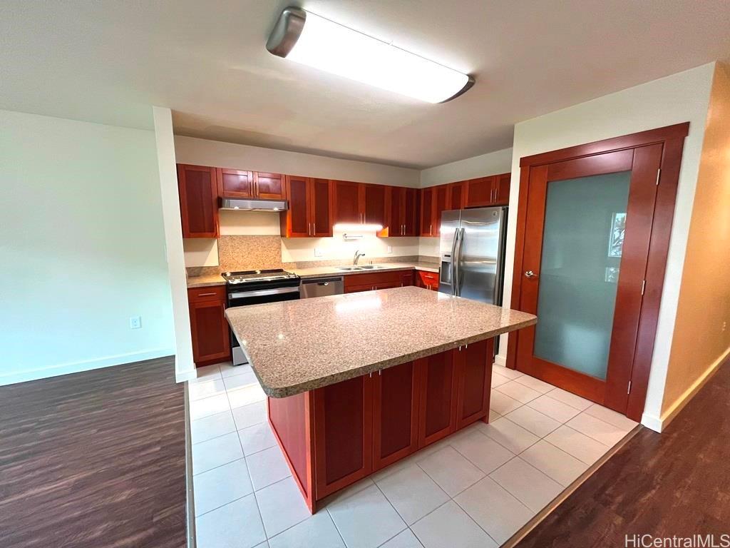 a kitchen with stainless steel appliances granite countertop a refrigerator a sink and a stove