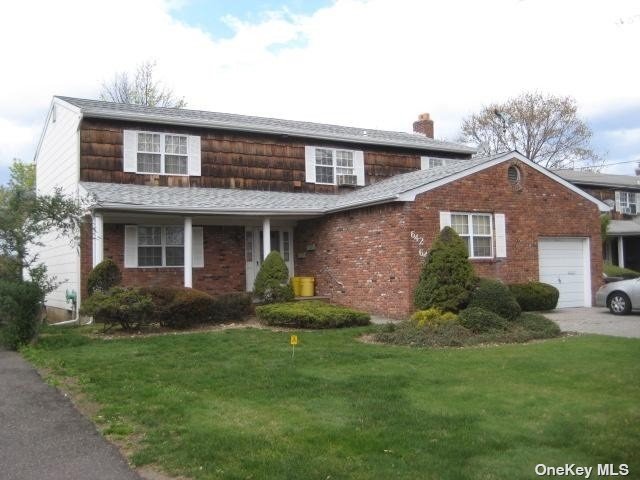 a front view of a house with a yard and porch