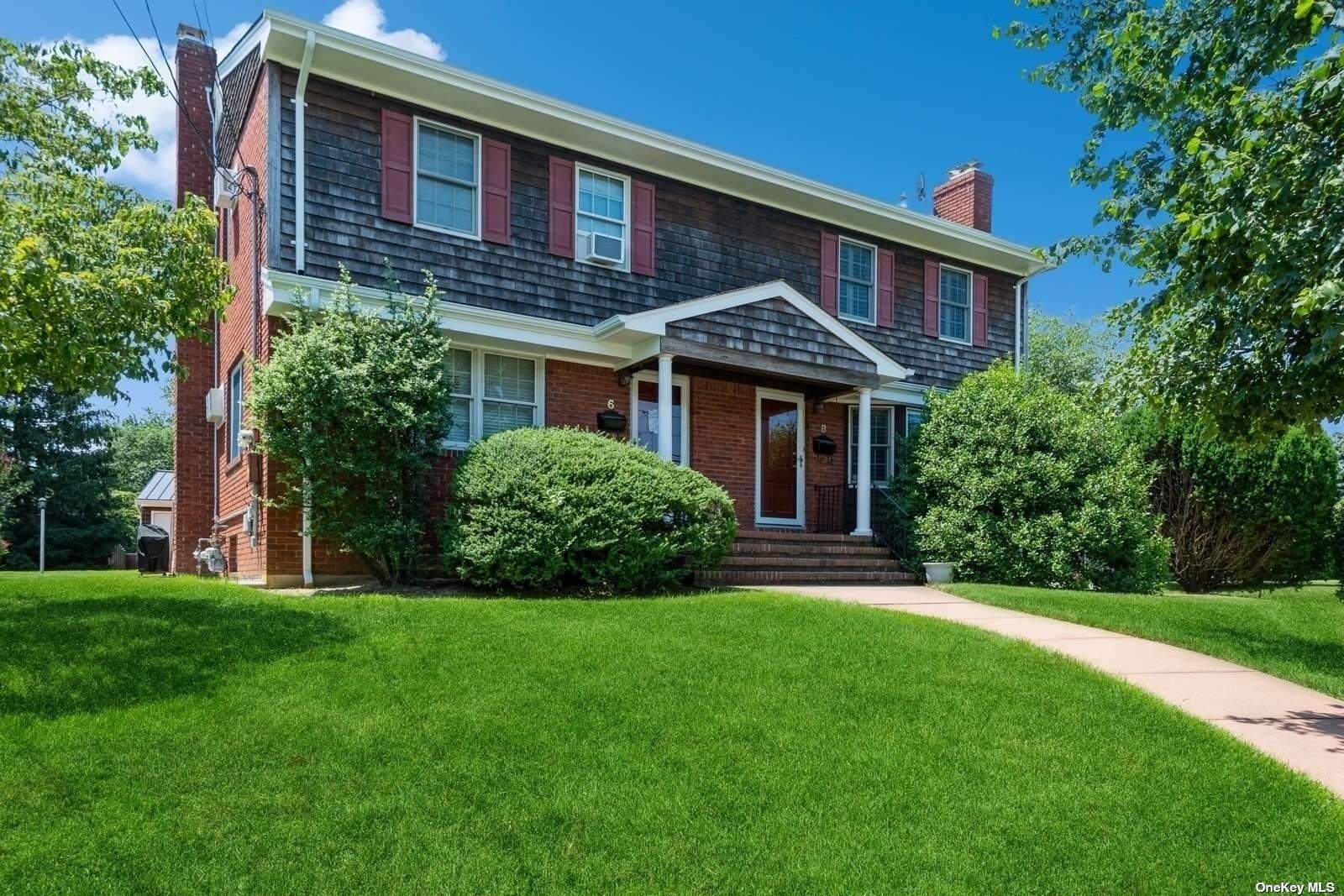 a front view of a house with a yard and trees