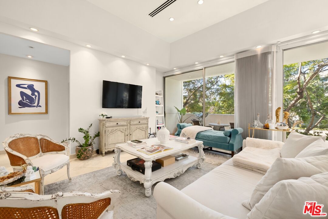 a living room with furniture a large window and a flat screen tv