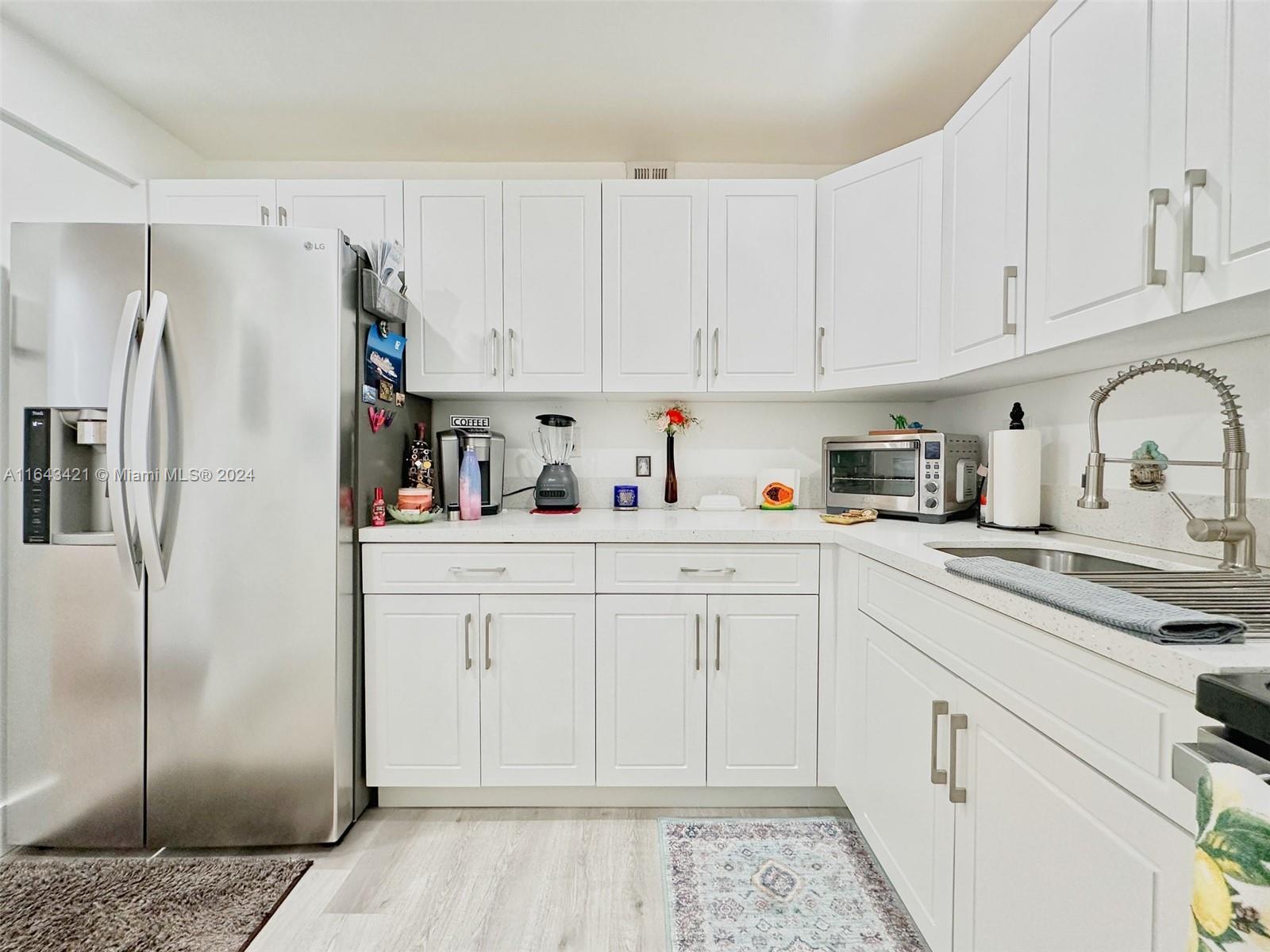 a kitchen with cabinets stainless steel appliances and a sink