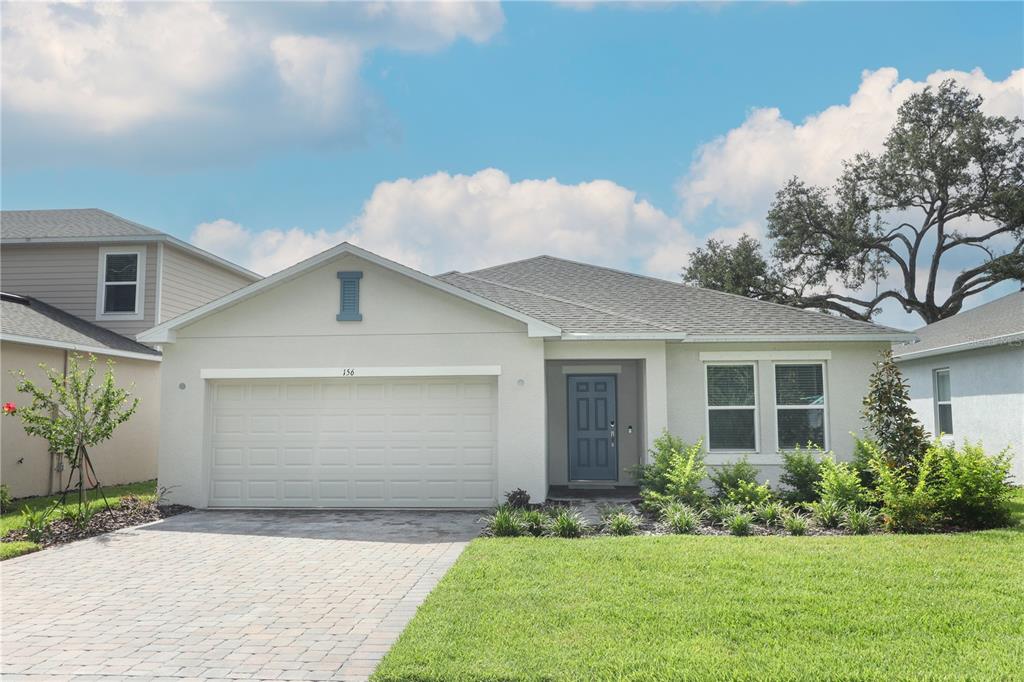 a front view of a house with a yard and garage