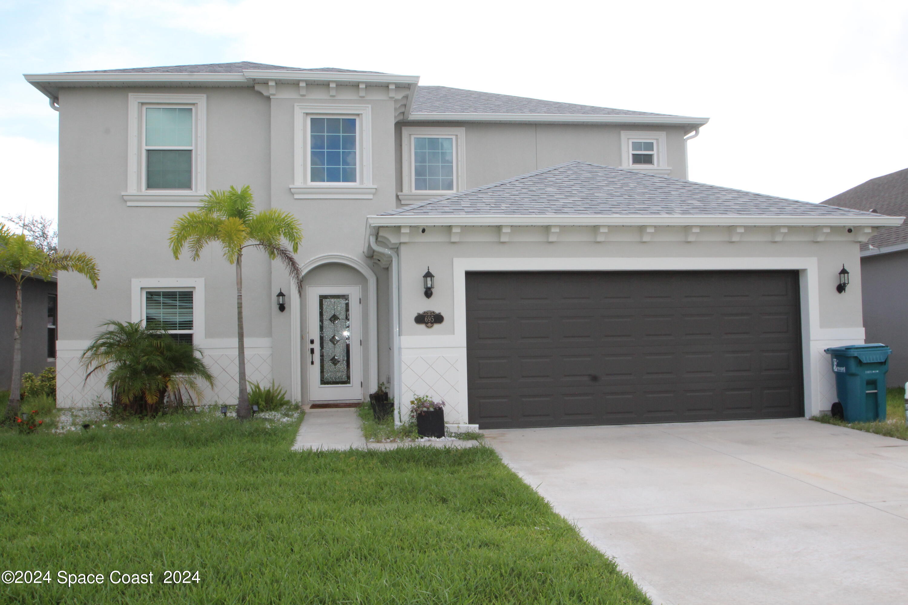 a front view of a house with a yard and garage