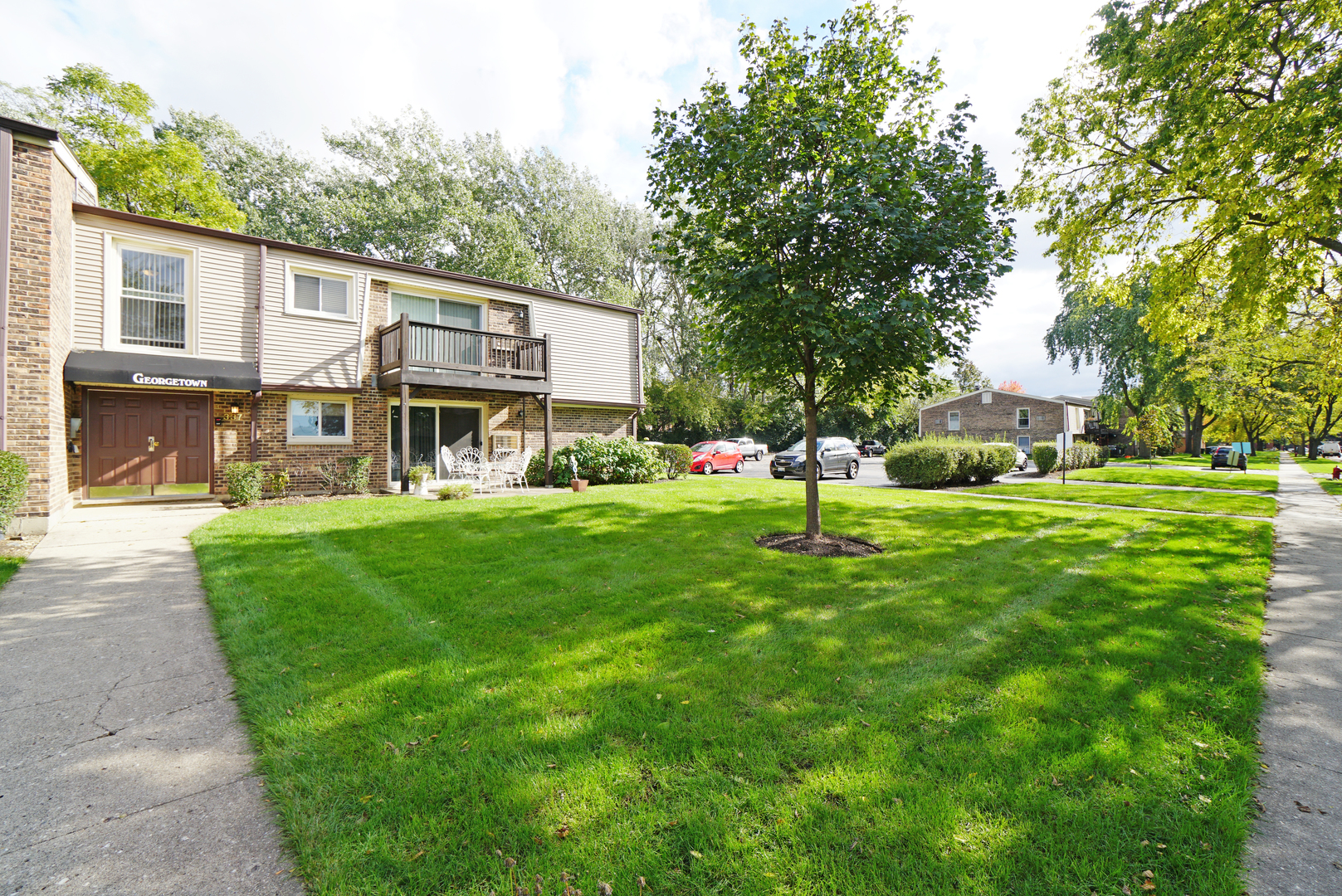 a front view of a house with a garden and trees