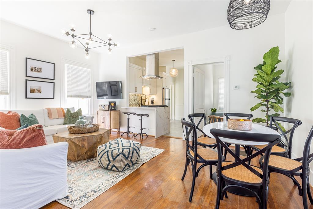 a living room with furniture a chandelier and a dining table