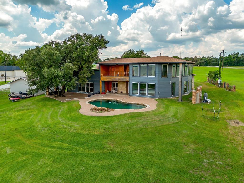 a view of a house with pool and a yard