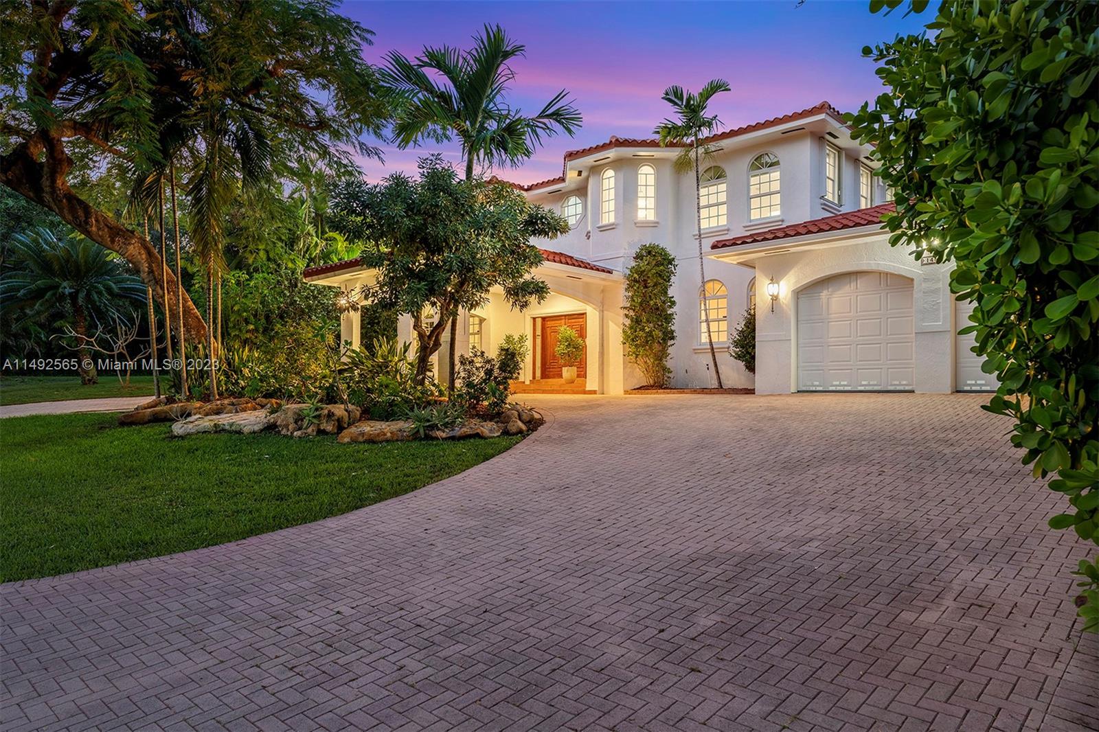 a front view of a house with a yard and trees