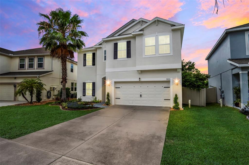 a front view of a house with a yard and garage