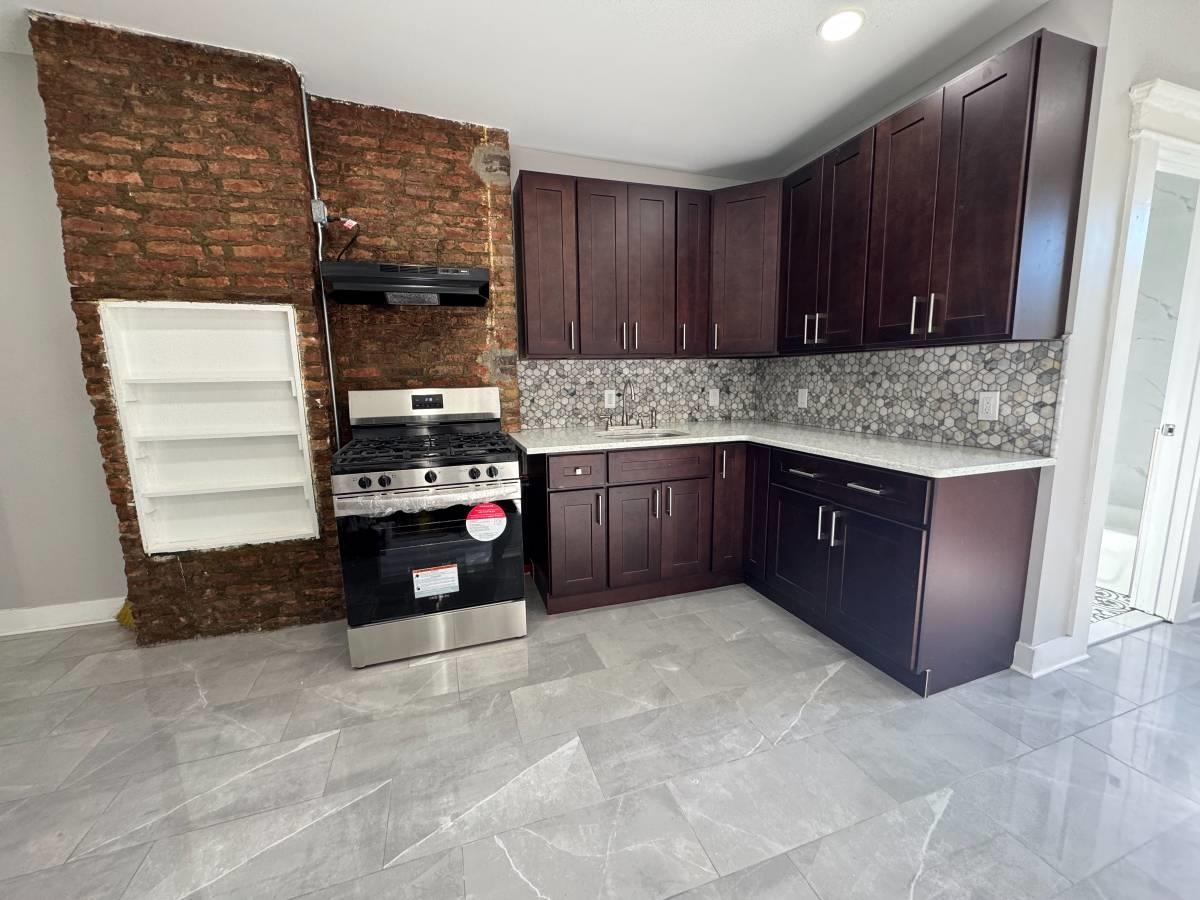 a kitchen with stainless steel appliances granite countertop a stove a sink and a microwave