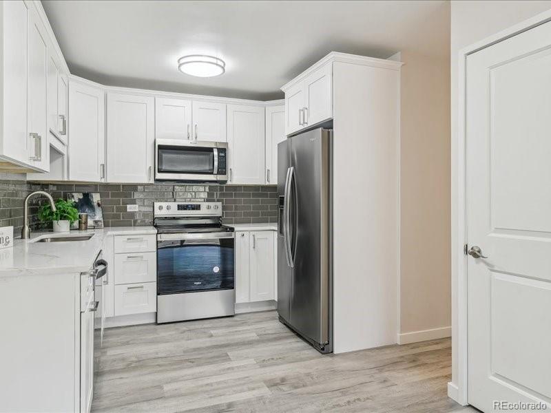 a kitchen with a refrigerator stove and sink