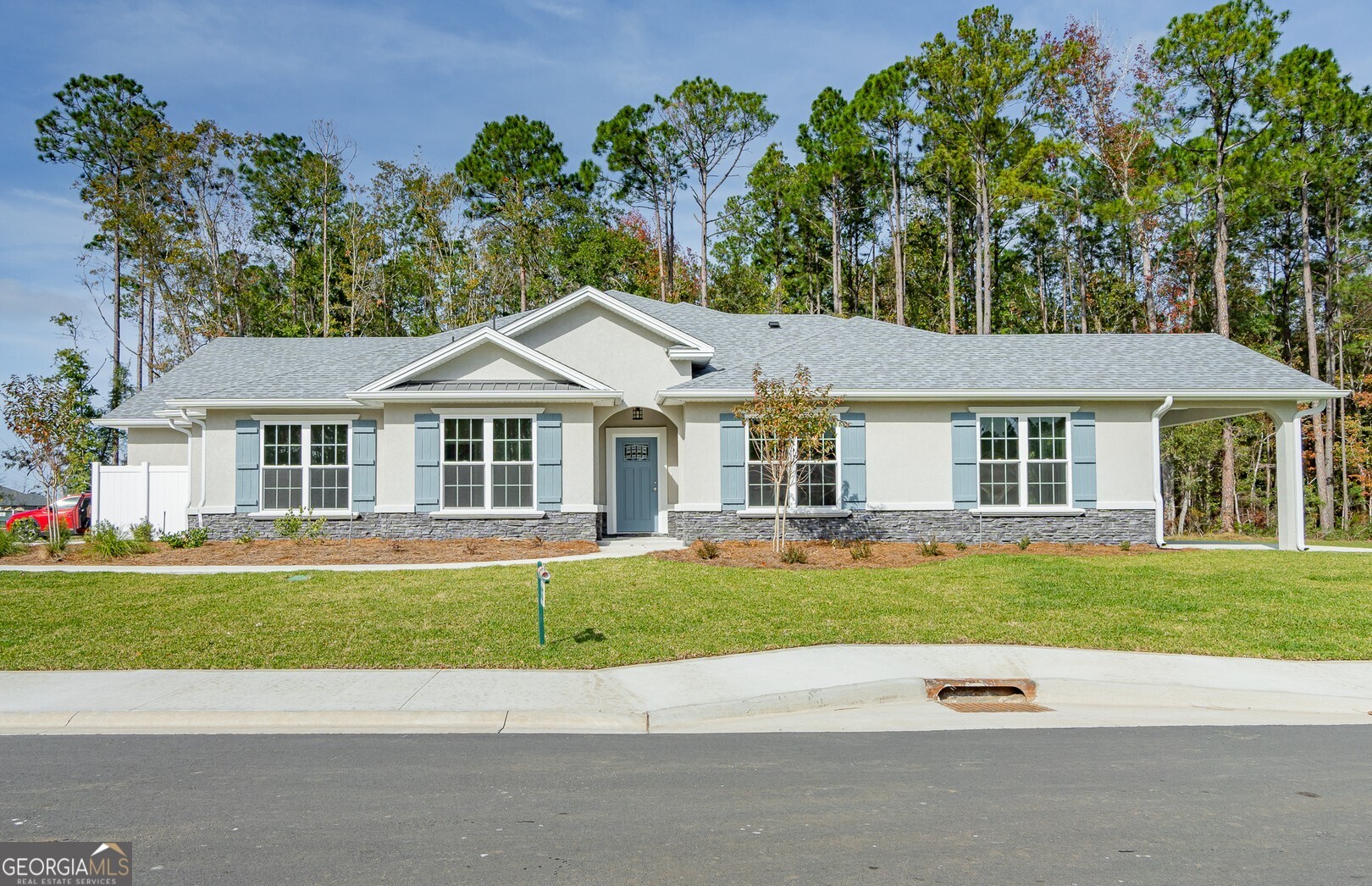 a front view of a house with a garden and trees