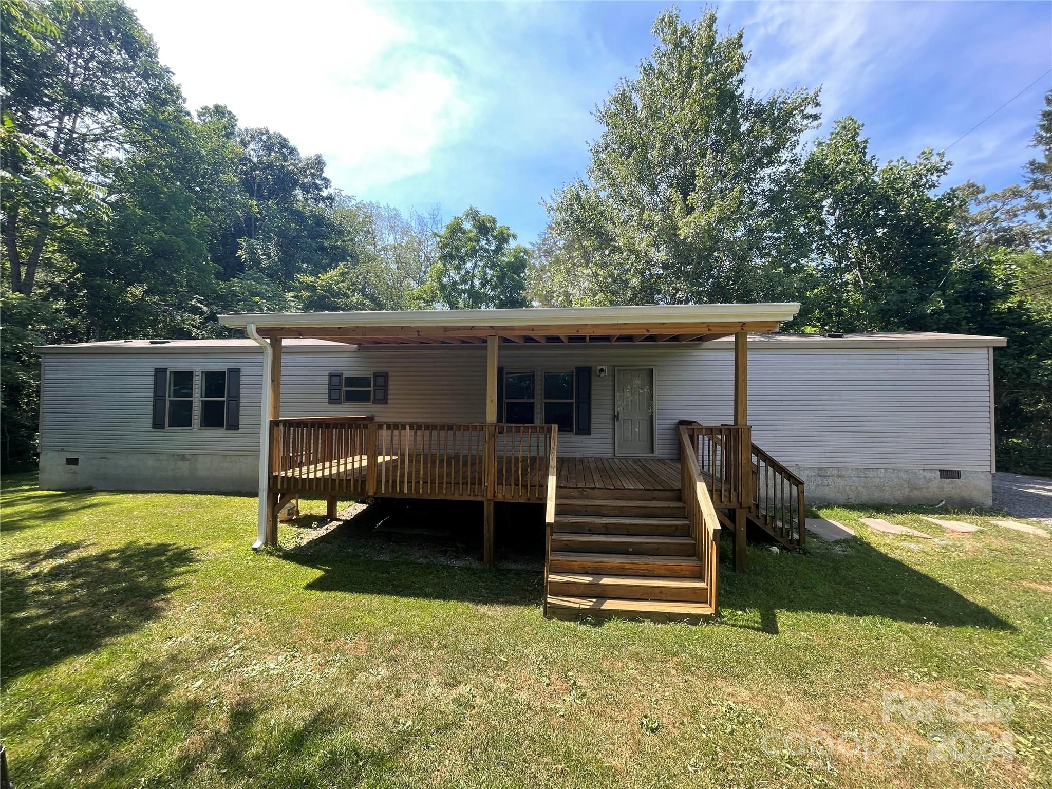 a view of a house with backyard and a tree