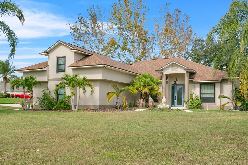 a front view of a house with a yard and trees