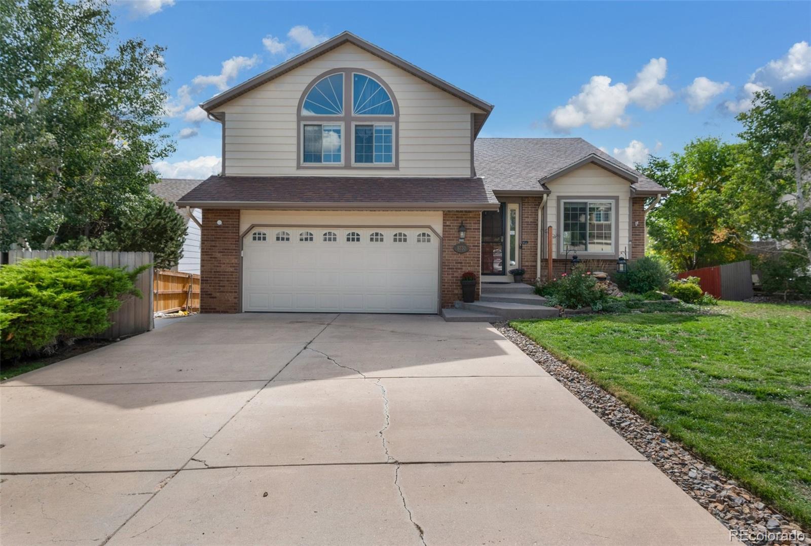 a front view of a house with a yard and a garage