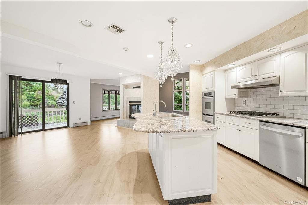 Kitchen featuring a healthy amount of sunlight, an inviting chandelier, sink, and appliances with stainless steel finishes