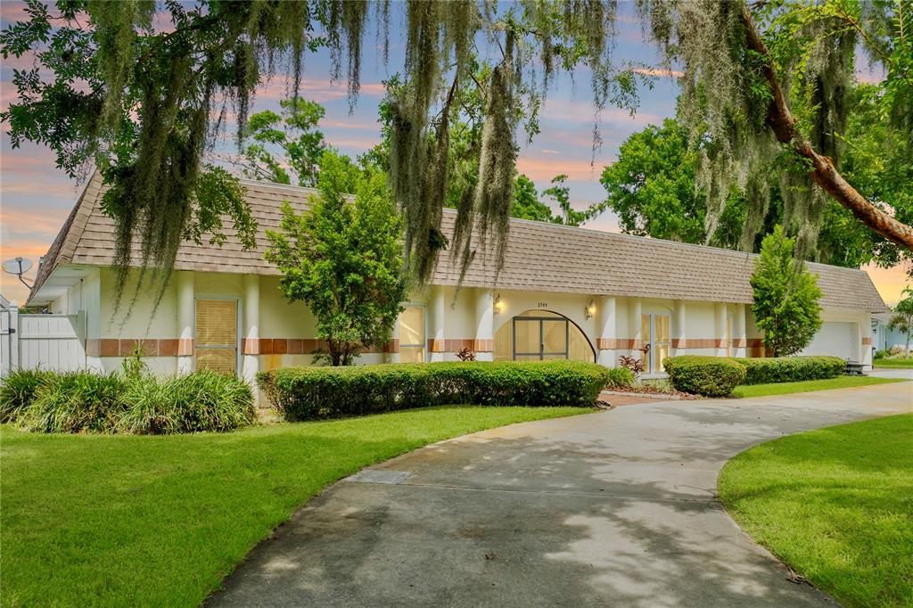 a front view of a house with a garden and plants