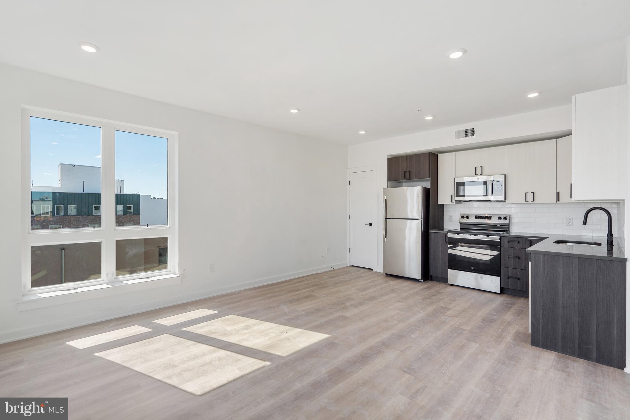 a kitchen with stainless steel appliances granite countertop a refrigerator and a stove top oven