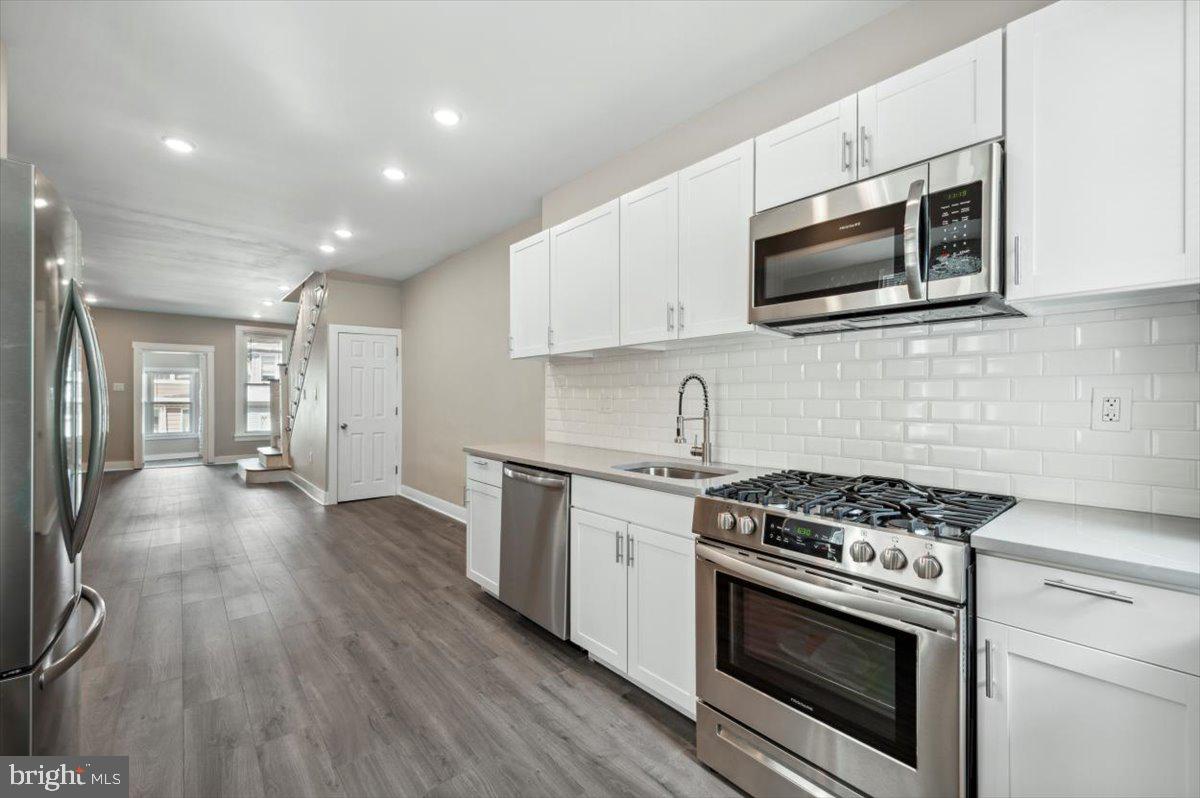 a kitchen with stainless steel appliances white cabinets granite counter tops and a stove