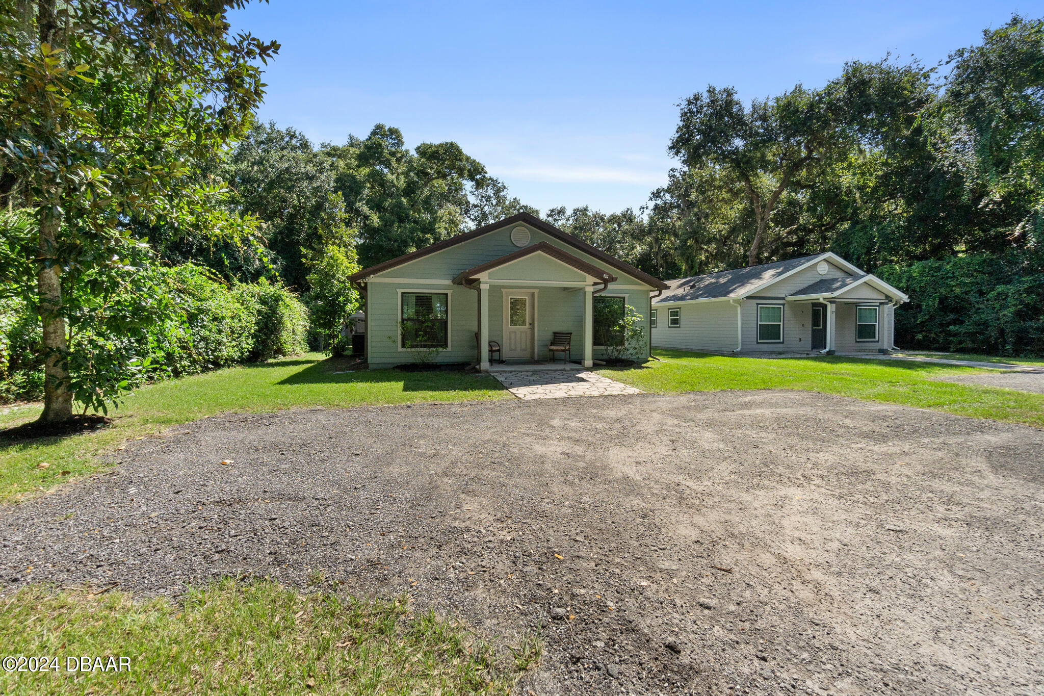 a front view of a house with a big yard and large trees