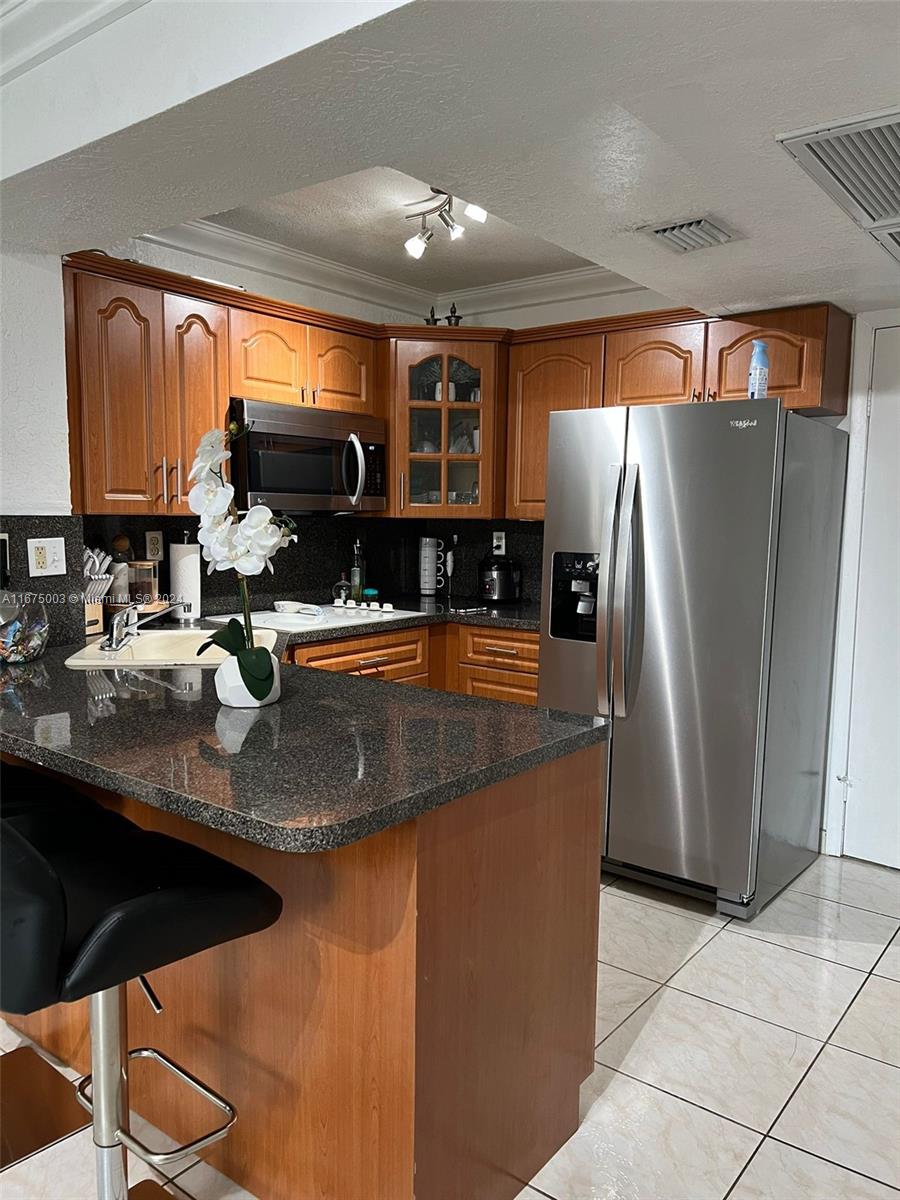 a kitchen with stainless steel appliances granite countertop a sink a stove and a refrigerator