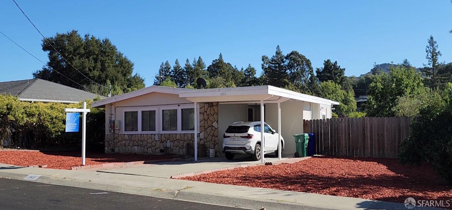 a view of a house with yard and sitting area