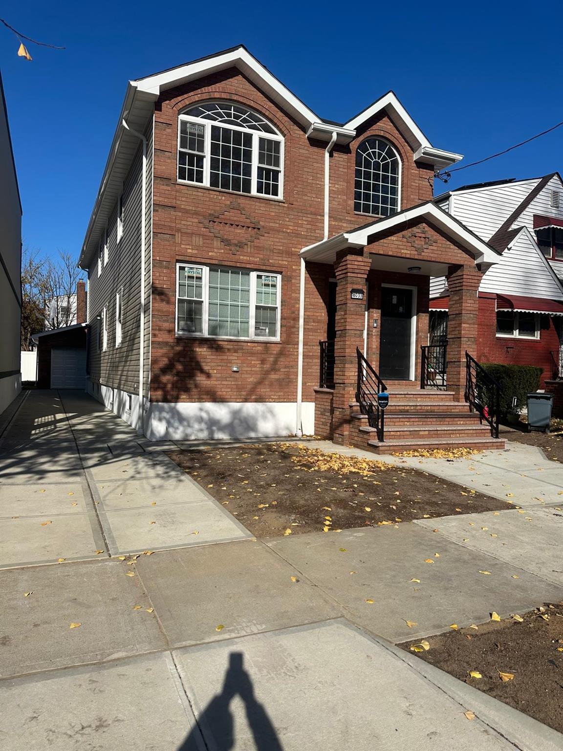 View of front of home with a garage and an outdoor structure