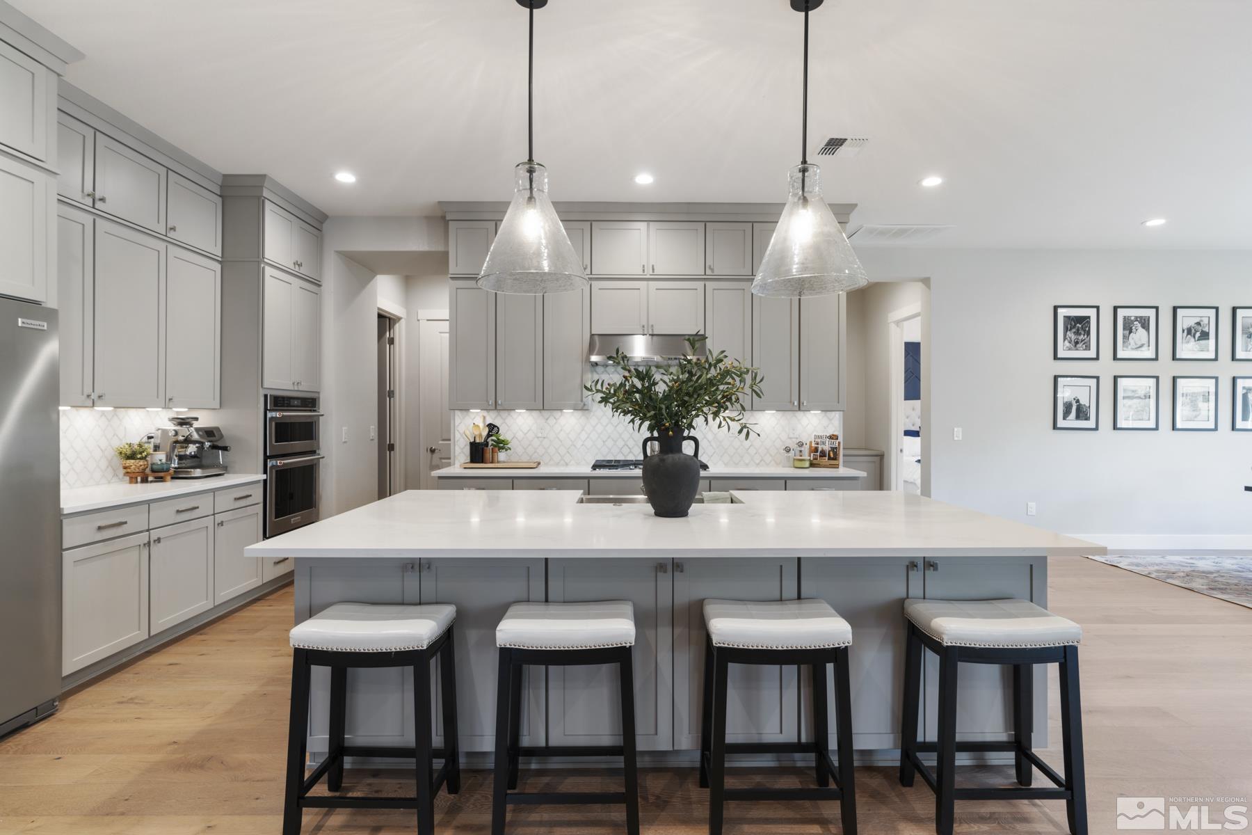 a kitchen with kitchen island a dining table and chairs