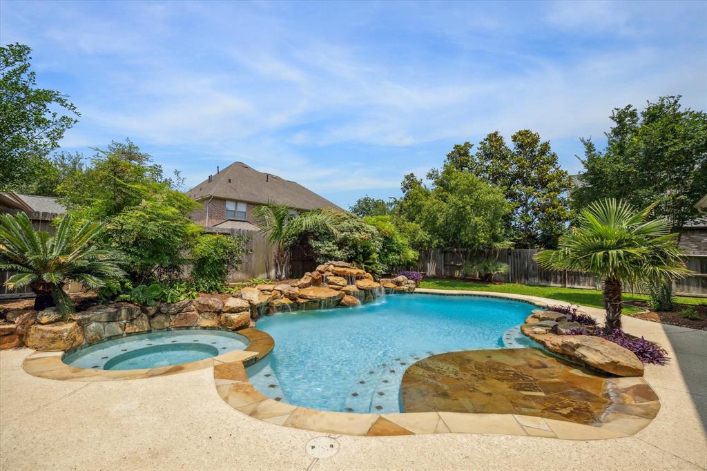 a view of a swimming pool with lawn chairs under an umbrella