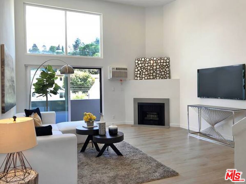 a living room with furniture a flat screen tv and a fireplace