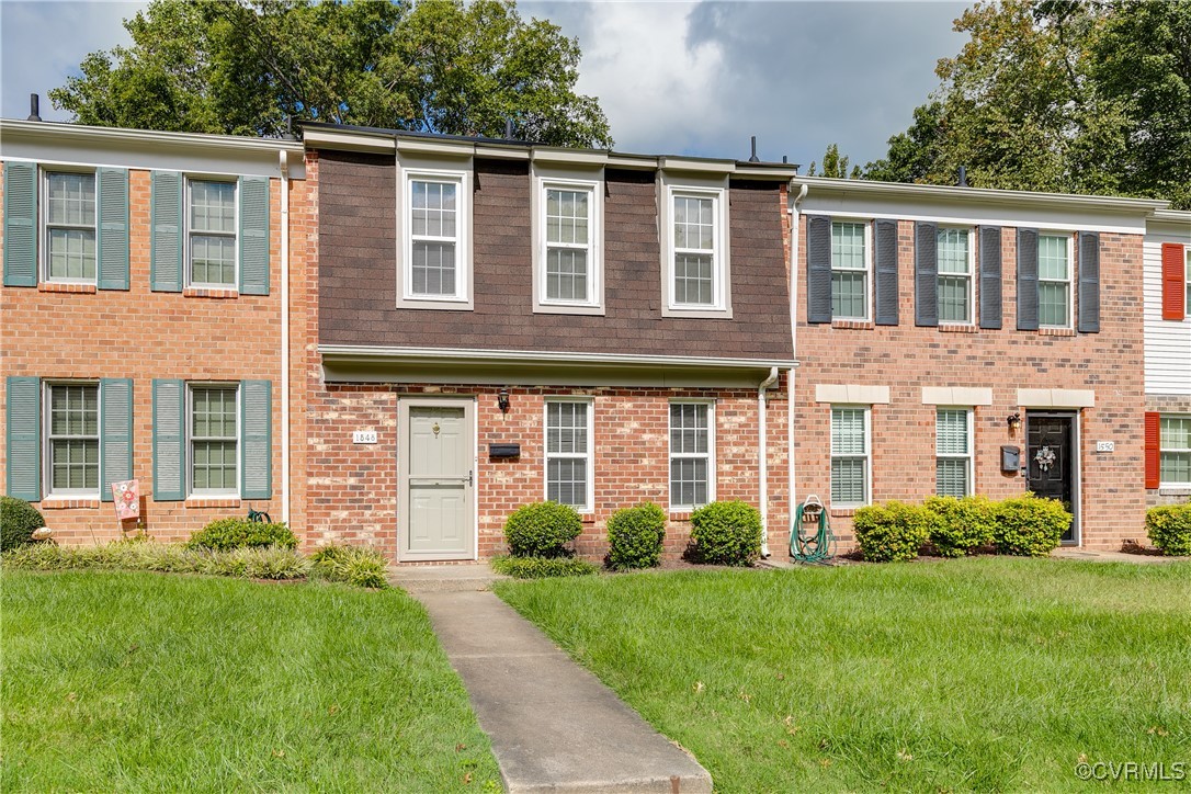 front view of a brick house with a yard