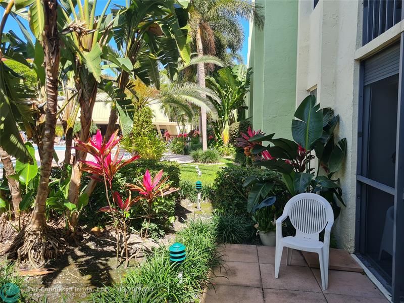 a view of a chair and table in a backyard of a house